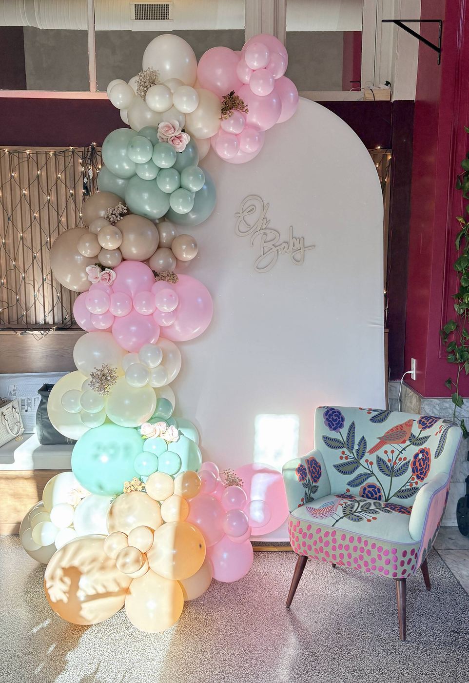 Pastel balloon garland in blush, mint and white climbing a pair of arched backdrops