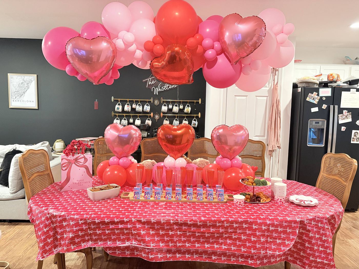 Red and pink heart balloon garland over a Valentine table
