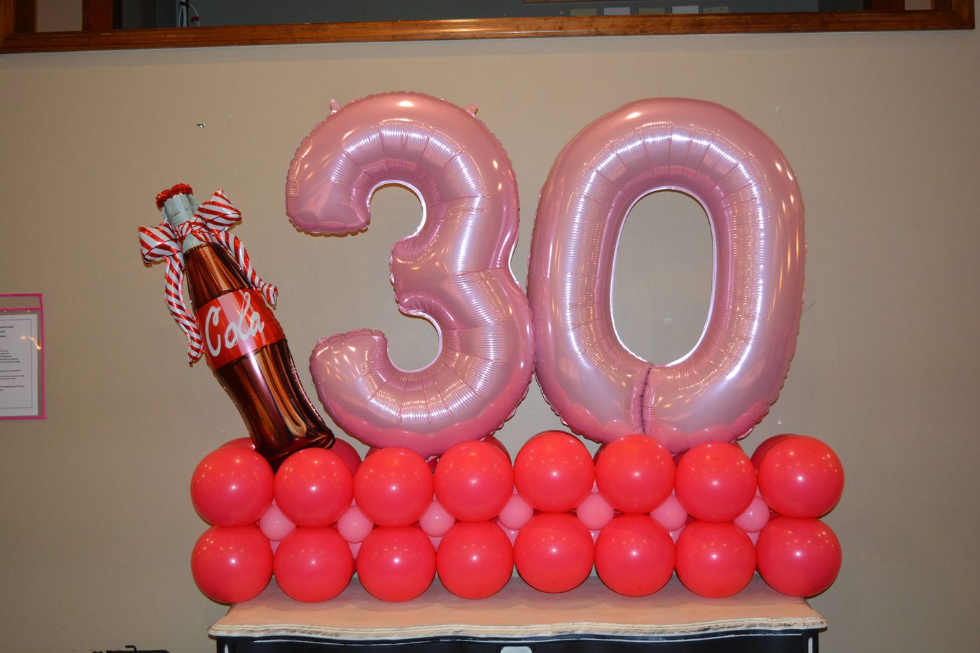 Pink 30 number balloons standing on a red balloon base
